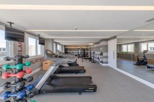 a gym with treadmills and machines in a room at LOFT1304 Maxplaza Canoas in Canoas