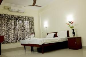 a bedroom with a bed with a black and white curtain at Dew Drops Inn kovalam in Kovalam