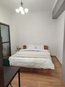 a white bedroom with a large bed and a table at Mikado lounge in Itʼkhvisi