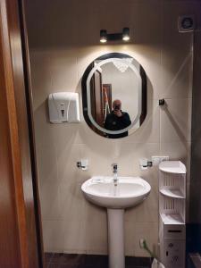 a man taking a picture of a sink in a bathroom at Mikado lounge in Itʼkhvisi +18 photos