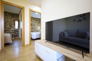 a living room with a large flat screen tv at YourHouse Casa Antonio in Sobrado del Obispo