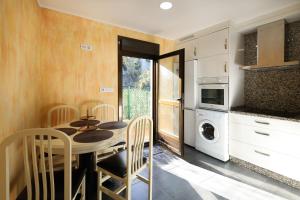 a kitchen and dining room with a table and chairs at YourHouse Casa Antonio in Sobrado del Obispo