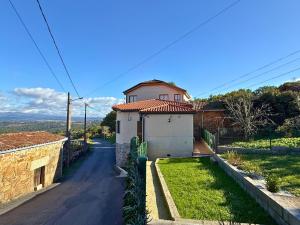 a small house on a street with a road at YourHouse Casa Antonio in Sobrado del Obispo