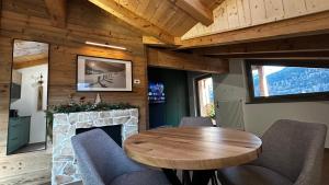 a dining room with a wooden table and a fireplace at Alpen Lodge Premium Apartment in Mezzana