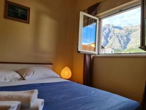 a bedroom with a bed and a window with a mountain view at Apartmani OREBIĆ in Orebić