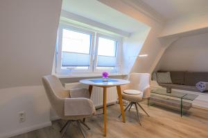 a small room with a table and chairs and a bed at Ferienwohnung-NEU-Weidenstieg-OG in Wenningstedt