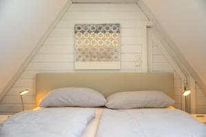 a bed with two pillows on it in a attic at Ferienwohnung-NEU-Weidenstieg-OG in Wenningstedt