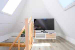 a living room with a tv and a table at Ferienwohnung-NEU-Weidenstieg-OG in Wenningstedt