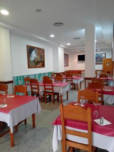a dining room with red and white tables and chairs at El Ancla Ponferrada in Ponferrada