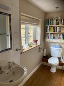 a bathroom with a sink and a toilet and a window at Brook Farm Cottage in Brackley +39 photos