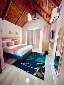 a bedroom with a bed and a rug on the floor at Pula Zone Chalets in Maun