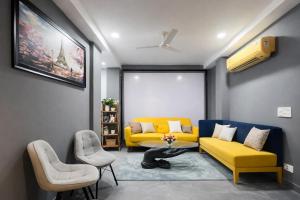 a living room with a yellow couch and two chairs at The Boutique Studio Near Green Park Delhi- By ACESTAYZ in New Delhi