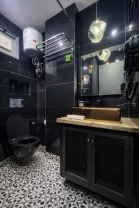 a black bathroom with a sink and a toilet at The Boutique Studio Near Green Park Delhi- By ACESTAYZ in New Delhi