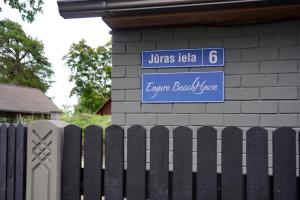 a blue sign on a building next to a fence at Engure BeachHouse in Engure