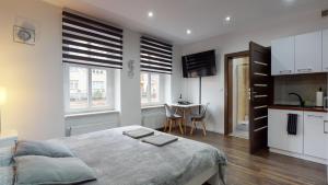 a bedroom with a bed and a kitchen with a table at Studio Fibra Dolce in Rybnik