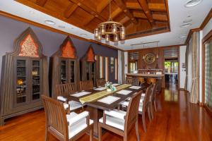 a dining room with a wooden table and chairs at Royal Legacy Golf Private Villa in Rawai Beach
