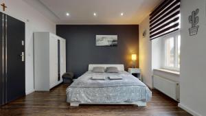 a bedroom with a bed and a black wall at Studio Fibra Dolce in Rybnik +6 photos