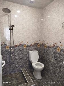 a bathroom with a toilet and a shower with flowers on the wall at AparanQ