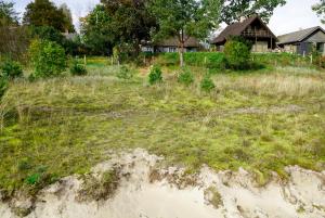 a field of grass with a house in the background at Engure BeachHouse in Engure