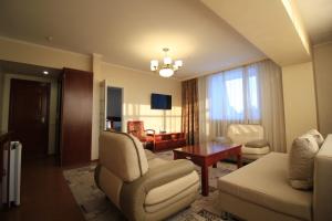 a living room with a couch chair and a table at Алма Ата in Borovoye