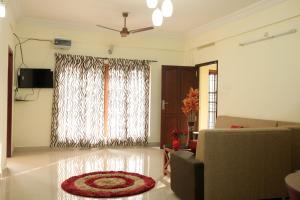 a living room with a couch and a large window at Dew Drops Inn kovalam in Kovalam