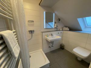 a bathroom with a sink and a toilet and a mirror at Hotel & Restaurant Friedrichshöhe in Braunschweig +58 photos