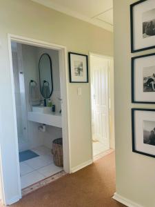a hallway with a bathroom with a mirror and a sink at Salt & Still in Freeland Park +23 photos