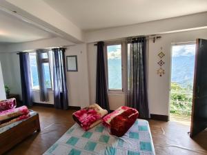 a living room with a couch and some windows at Petratos Homestay in Kalimpong
