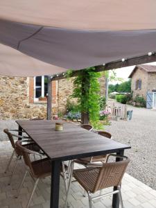 a table and chairs under an umbrella on a patio at Sharecroppers Cottage with Swimming Pool in Pagéas