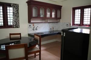a kitchen with a sink and a counter top at Dew Drops Inn kovalam in Kovalam