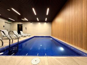 a swimming pool in a gym with chairs at Surxondaryo Hotel Tashkent in Teshabayguzar