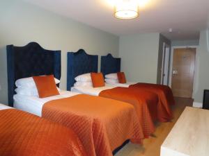 a room with three beds with orange blankets at The Stable Loft at Troysgate in Kilkenny