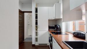 a kitchen with white cabinets and a counter top at Studio Fibra Doppio in Rybnik