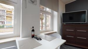 a living room with a white table and a tv at Studio Fibra Doppio in Rybnik