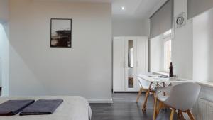 a white room with a bed and a table and chairs at Studio Fibra Doppio in Rybnik +16 photos