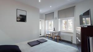 a white bedroom with a bed and a table with chairs at Studio Fibra Doppio in Rybnik