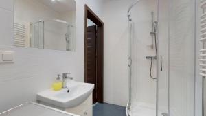 a white bathroom with a sink and a shower at Studio Fibra Doppio in Rybnik