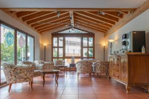 a living room with chairs and a table and a tv at Badehotel Salina Maris – Wellness & Vintage in Mörel