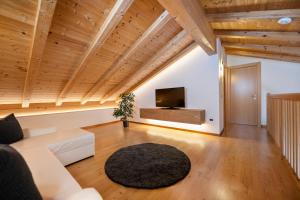 a living room with wooden ceilings and a flat screen tv at Apartments La Rives in Santa Cristina Gherdëina