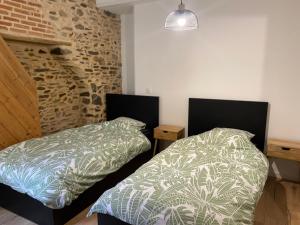 two beds sitting next to each other in a bedroom at Appartement Le Pellerin 2ch et 2sdb in Le Pellerin