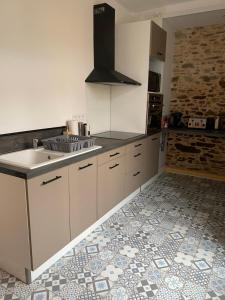 a kitchen with a sink and a stove in it at Appartement Le Pellerin 2ch et 2sdb in Le Pellerin