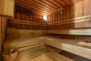 an empty wooden sauna with wooden floors and ceilings at Badehotel Salina Maris – Wellness & Vintage in Mörel