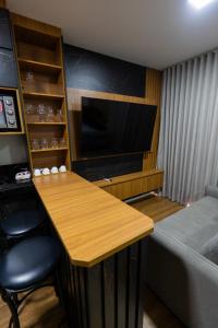 a room with a table and a tv and a bed at Flat exclusivo Studio Cuiabá 1211 in Cuiabá