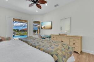 a bedroom with a bed and a dresser and a window at Sunsets At Tiki Terrace in Cape Coral