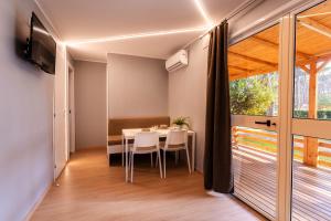 a dining room with a table and a large window at ISOLA VERDE Camping Village in Nettuno