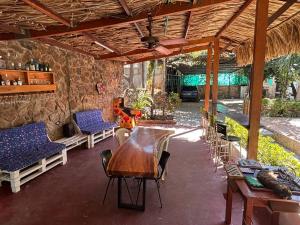 a patio with a table and chairs and a stone wall at Hostal Los Arhuacos in Santa Marta