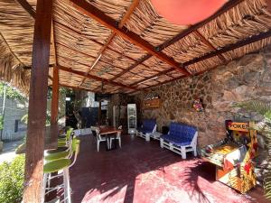 a patio with chairs and a table and a stone wall at Hostal Los Arhuacos in Santa Marta +33 photos