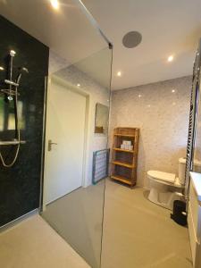 a bathroom with a glass shower and a toilet at White Cliff Rest in Seaford +24 photos
