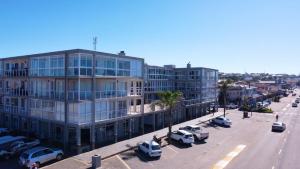 a large building with cars parked in a parking lot at Perfect holiday destination! in Jeffreys Bay