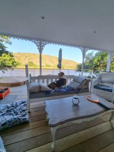 a woman laying on a bed on a deck at Jonker's Cottage in Malgas